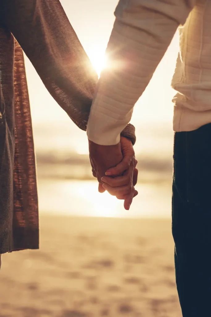 Couple holding hands with sunset
